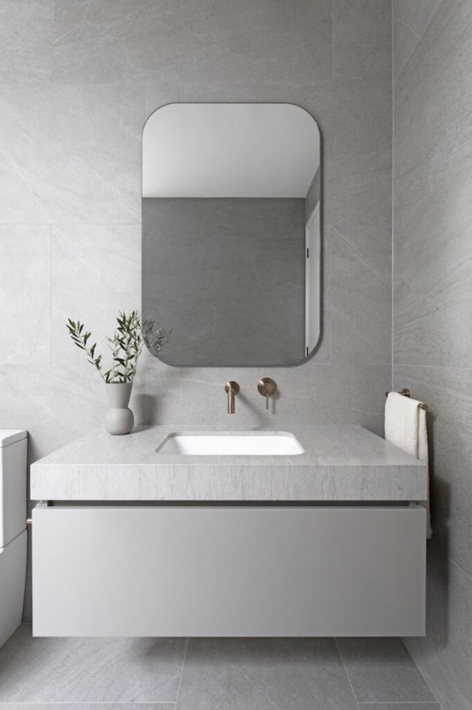 Modern under-counter wash basin installed beneath a sleek bathroom countertop with seamless contemporary design.